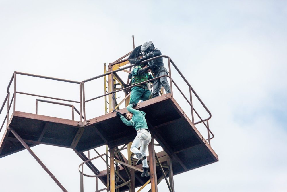 Stuntleute kämpfen auf einem Turm, eine Frau hängt runter