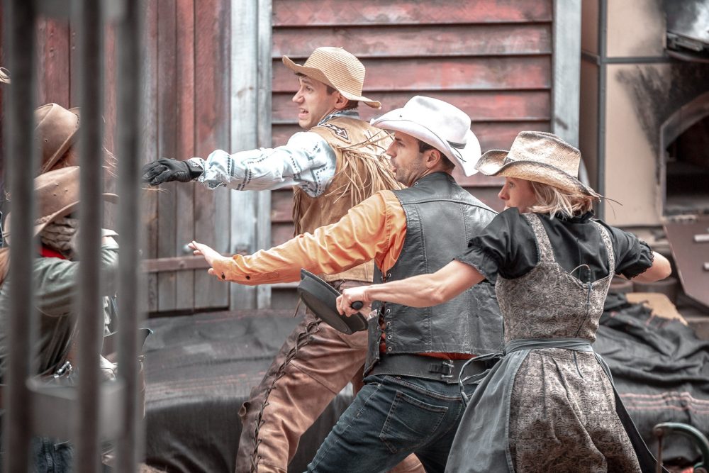 Drei Leute in Westernkleidung mit Cowboyhut