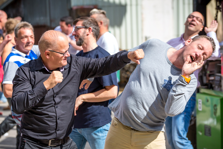 Mann im Schnupperworkshop wird von Stuntcrew angeleitet, wie ein Filmschlag auszuführen ist