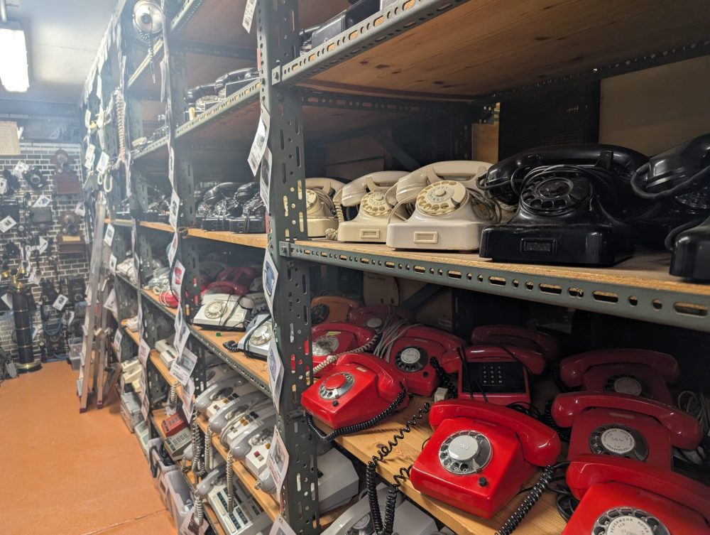 Viele alte Telefone in einem langen Regal